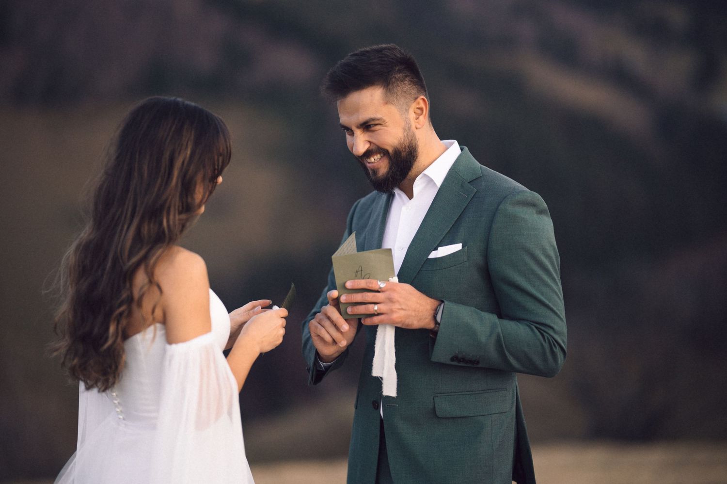 A couple stands together outdoors during a romantic engagement photo session in formal attire.