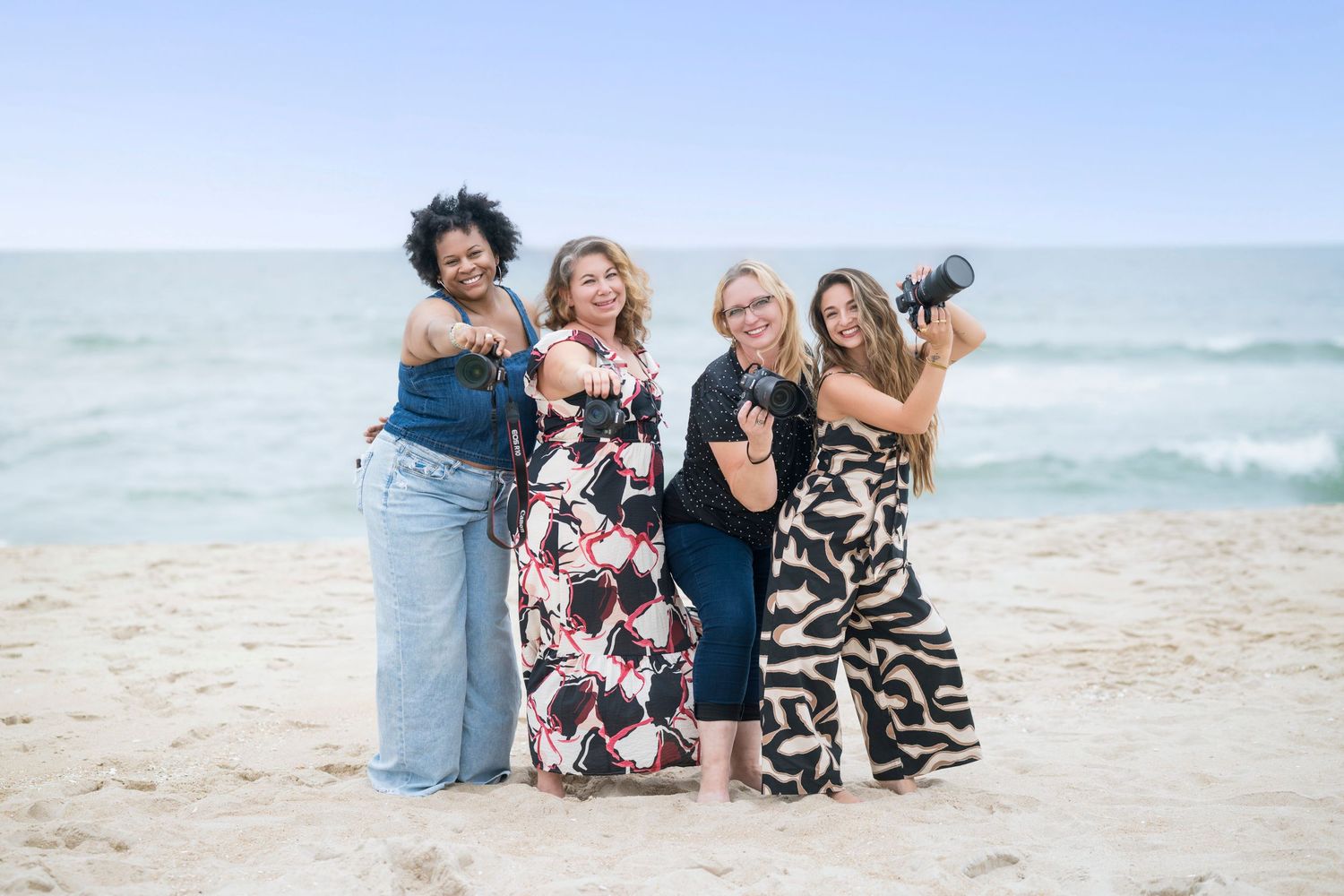 Group of photographers taking pictures together on a sunny beach.