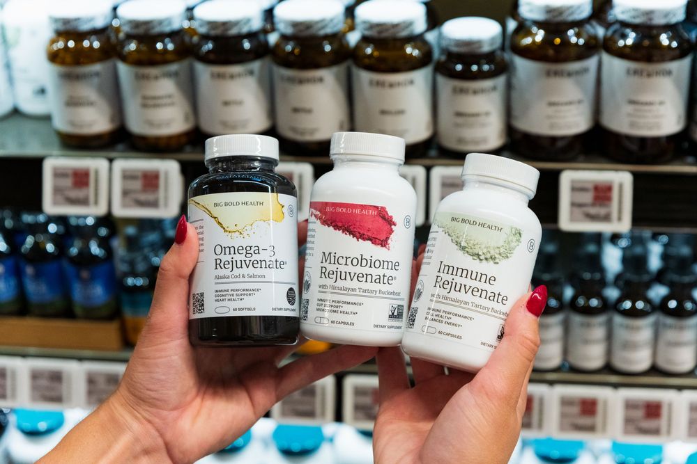 Row of dietary supplement bottles on store shelves displaying various nutritional products.