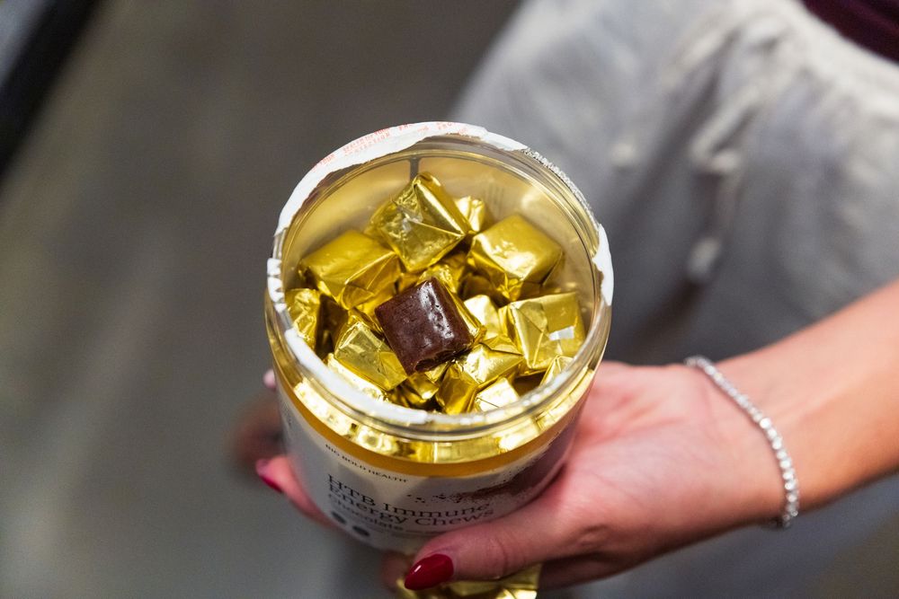 Golden supplement capsules being poured into glass bowls.