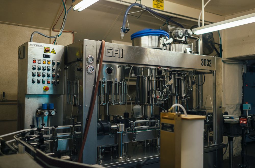 Industrial bottling machinery and control panels in a beverage production facility.