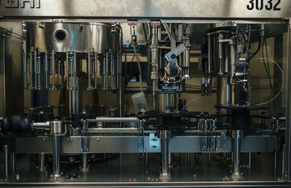 Automated bottling line machinery with stainless steel components and control systems.