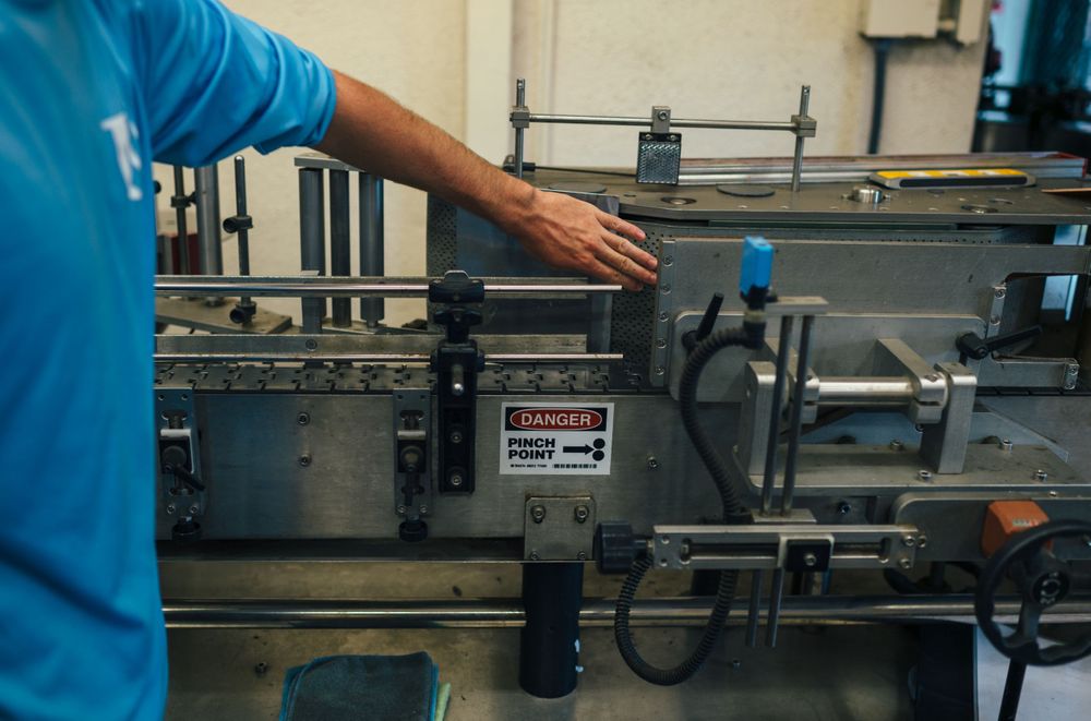 Industrial bottling line with automated machinery and conveyor belts in a manufacturing facility.
