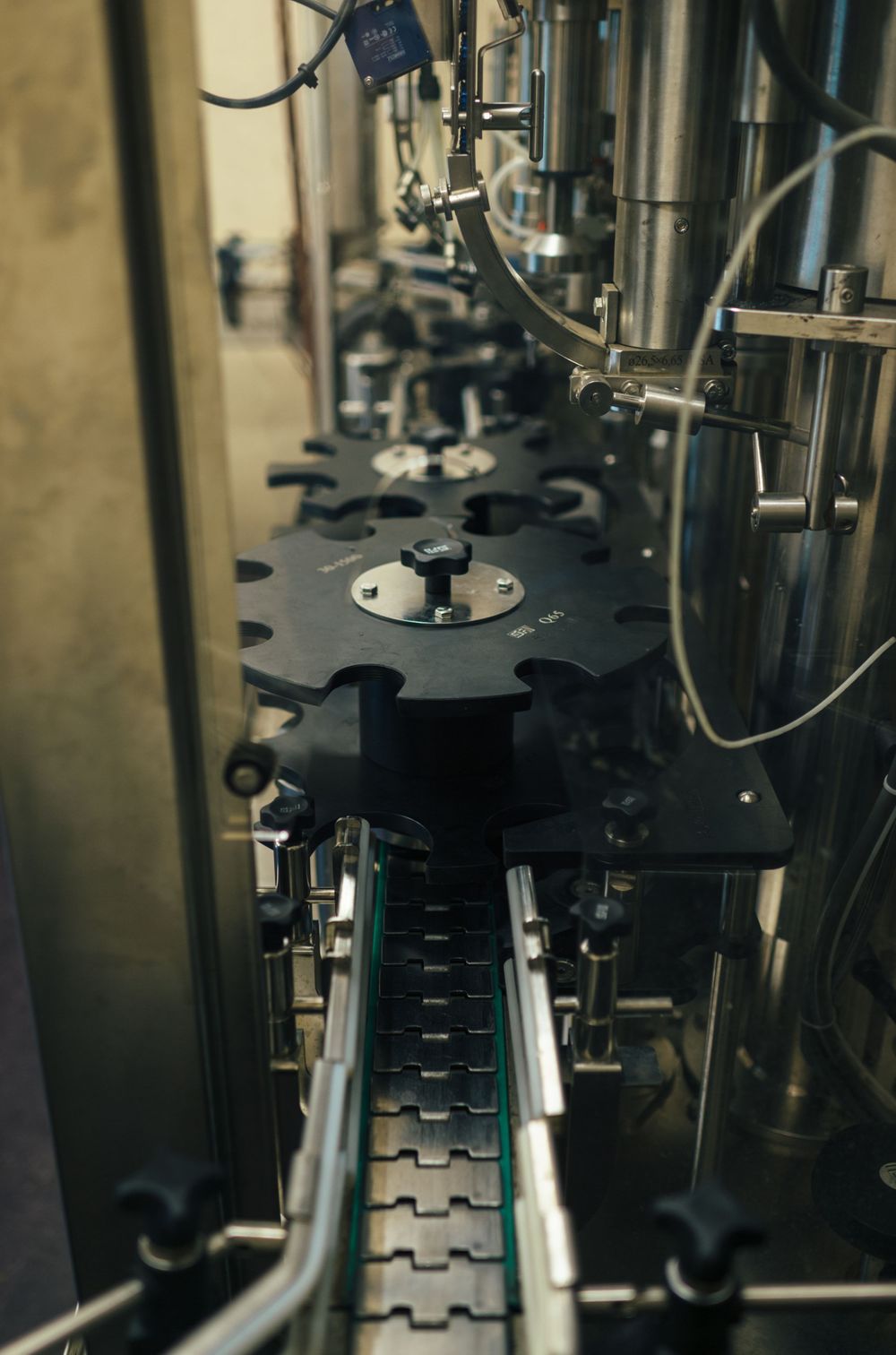 Close-up view of an automated bottle conveyor system with precision filling mechanisms.