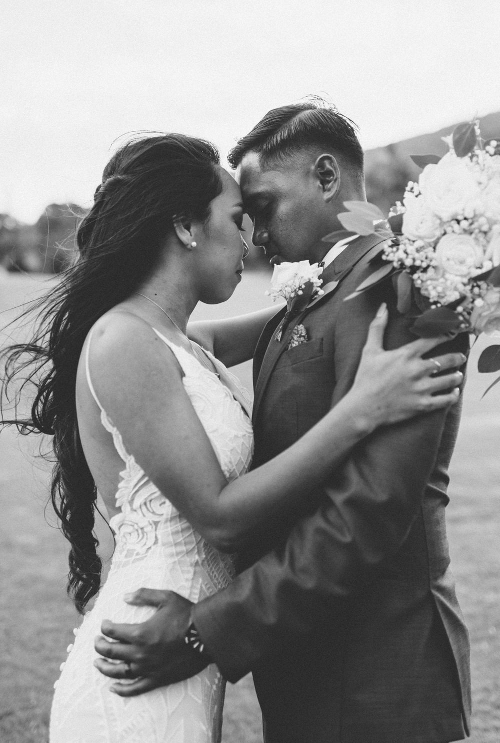 Black and white romantic wedding couple portrait with intimate embrace.