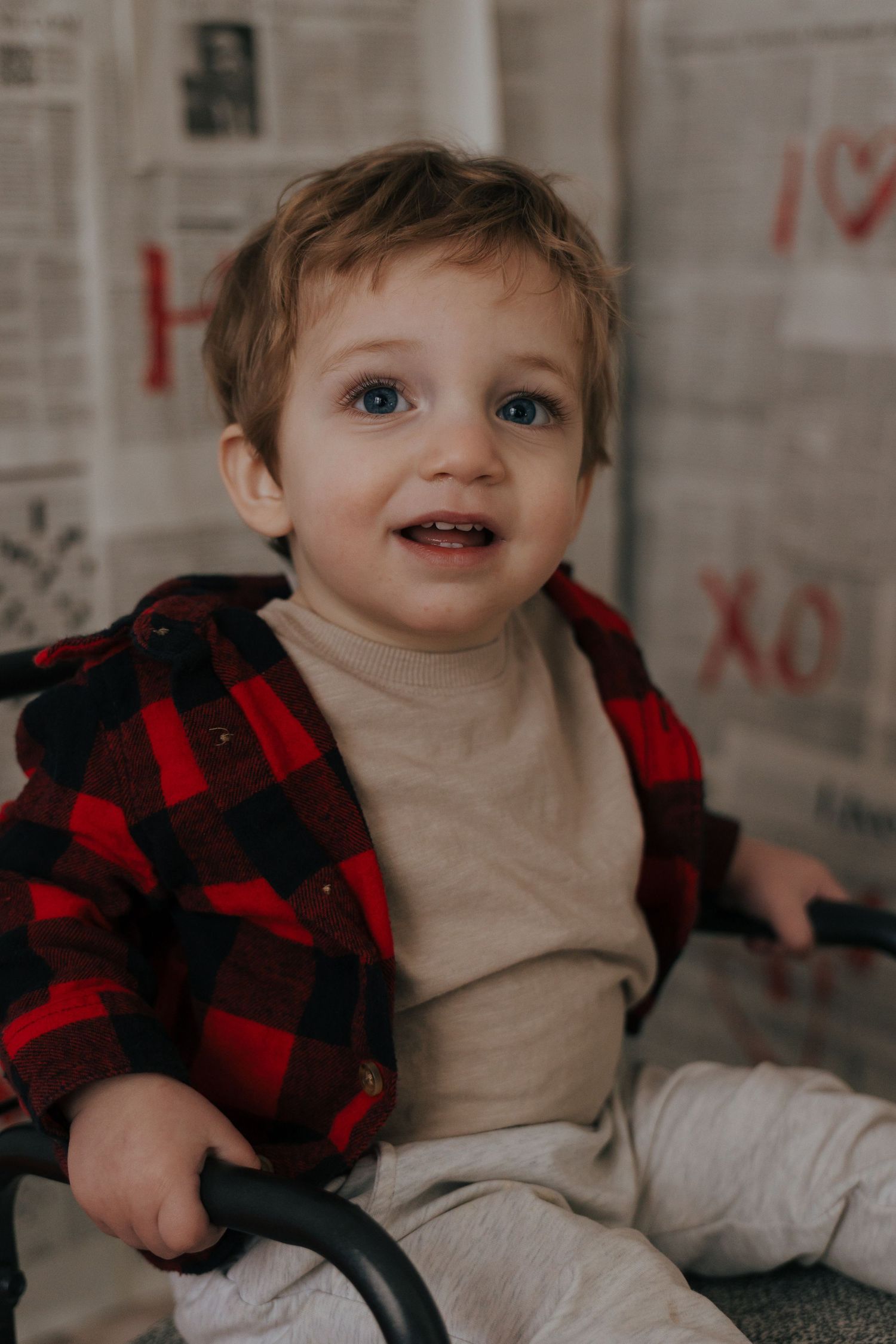 A cozy winter scene with red buffalo plaid and cream colored clothing against a neutral background.