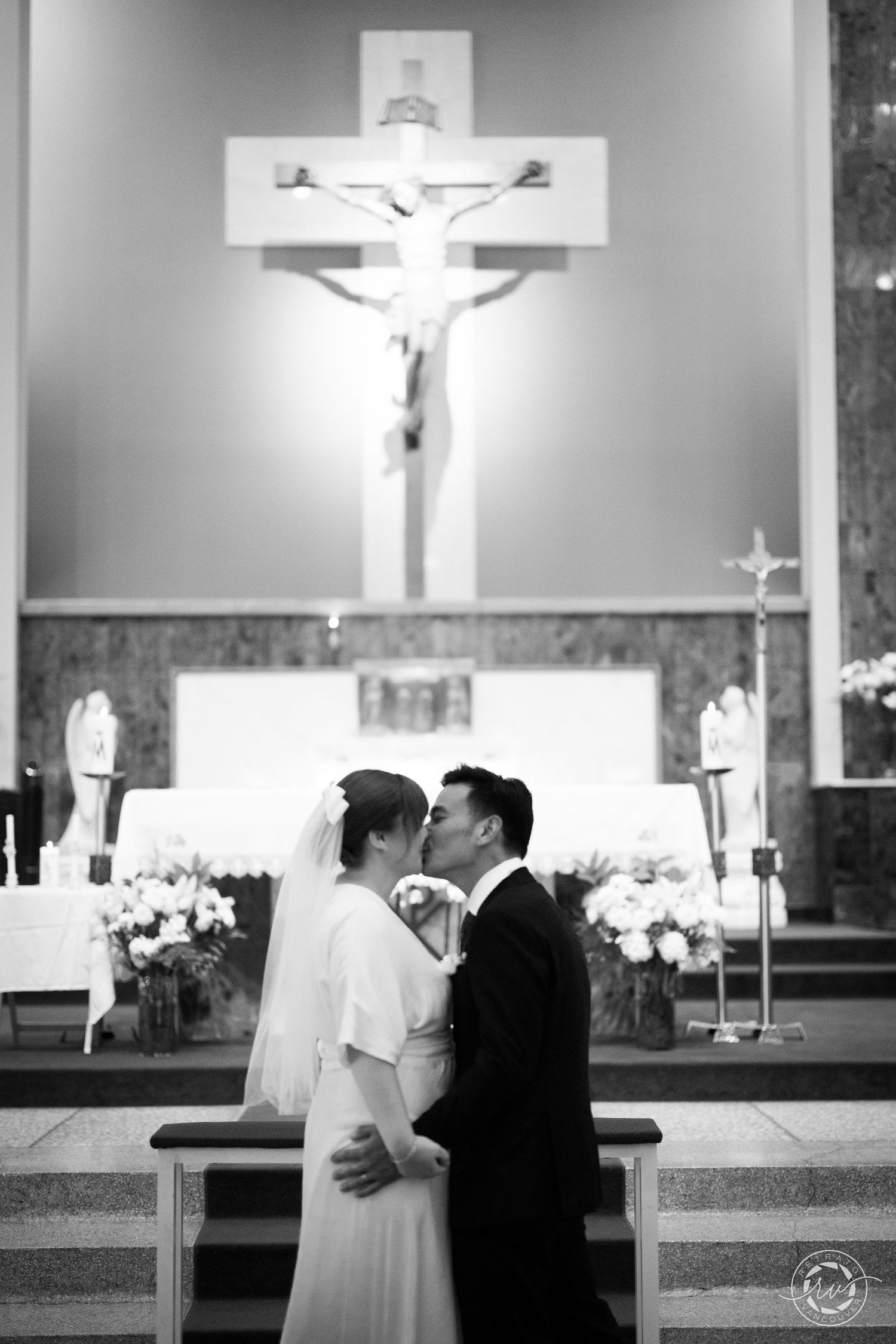 A wedding ceremony in progress inside a church with crosses and religious symbols visible.