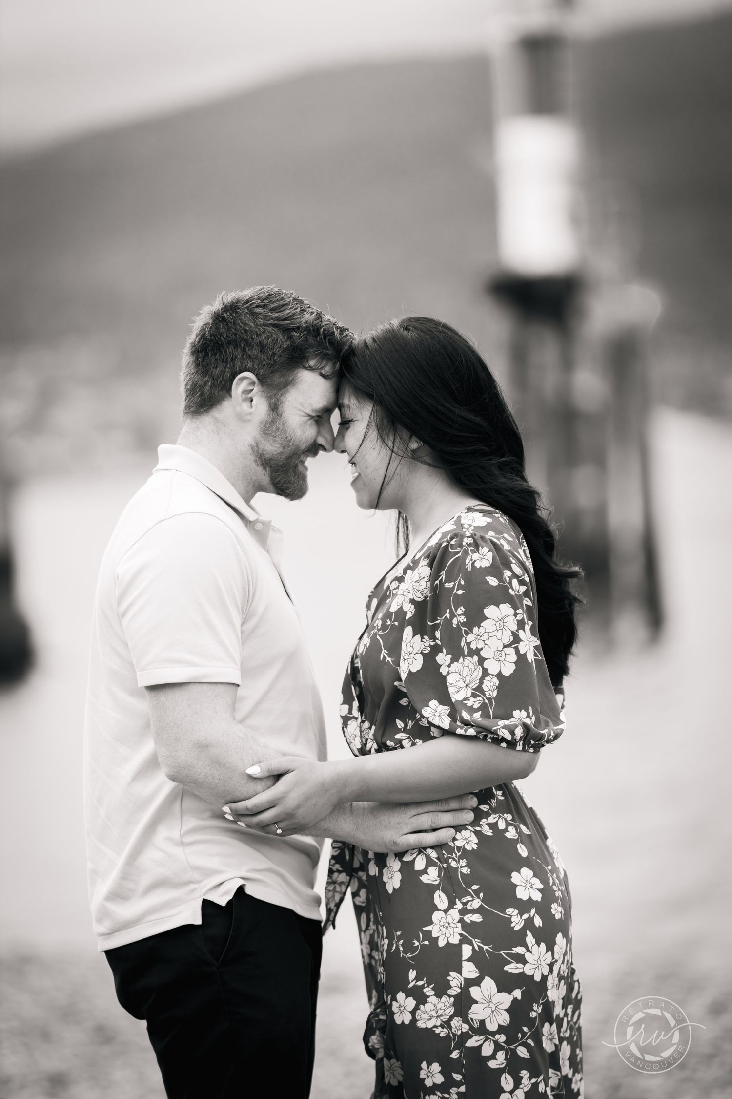 A couple shares an intimate moment during a black and white maternity photoshoot.