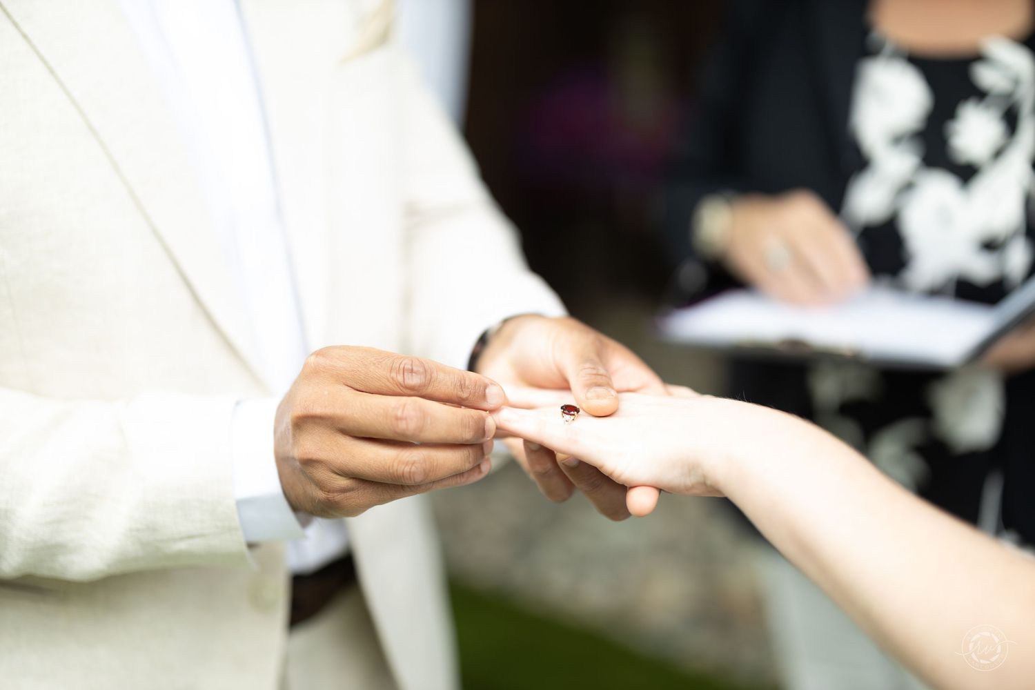 Close-up shots of hands exchanging rings during a wedding ceremony.