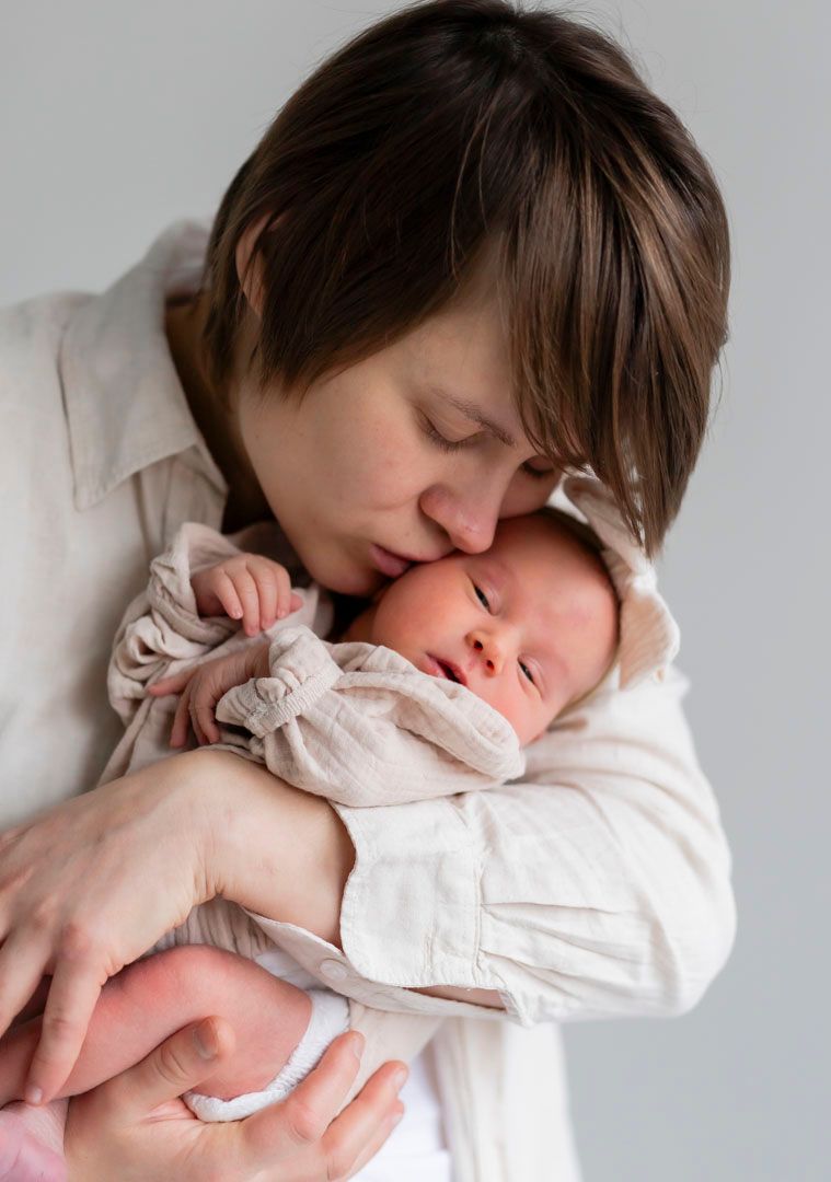 Äiti syleilee vastasyntynyttä, newbornkuvaus Muurame, herkkä ja tunteita herättävä kuva