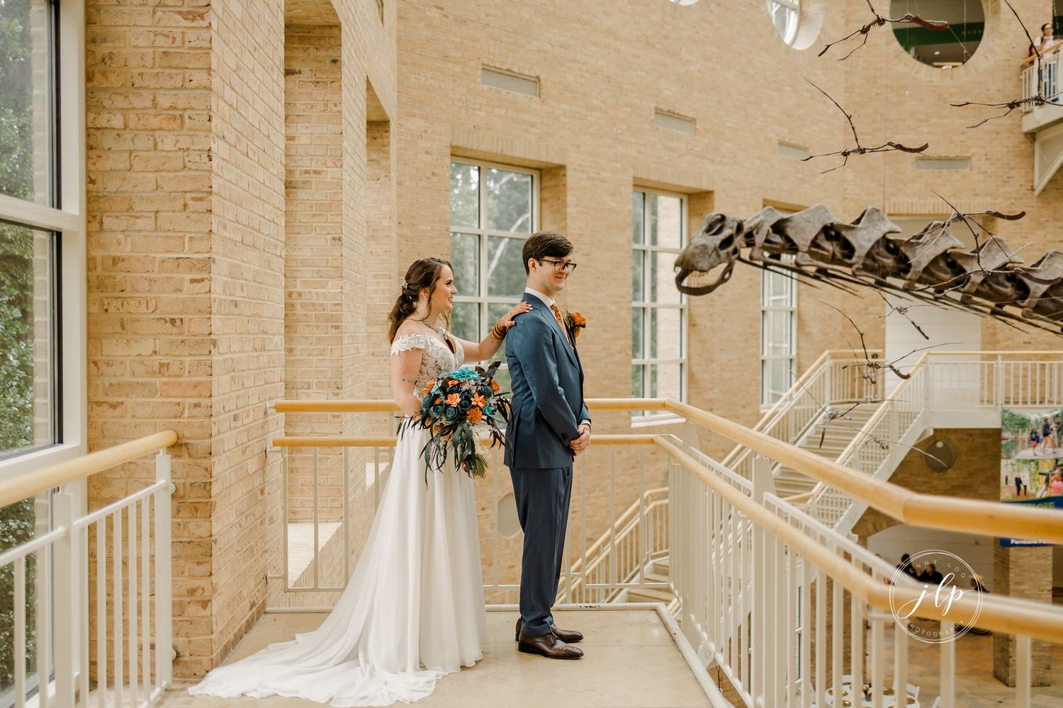 Couple shares romantic moments on stone balcony of Spanish colonial building.