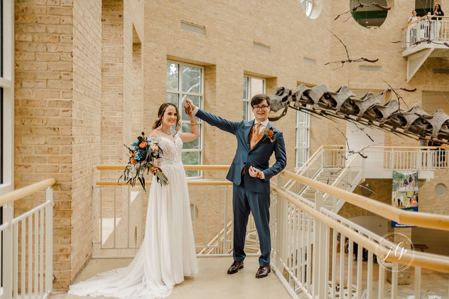 Bride and groom meet in an elegant indoor venue with exposed brick walls and white beams.