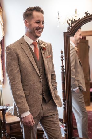 Series of getting ready shots showing details of a brown tweed wedding suit.