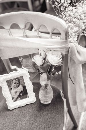 Black and white photo showing people arranging wedding decorations and floral arrangements on a carpeted floor.