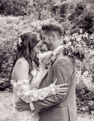 A romantic black and white photo sequence showing embraces and tender moments in a garden setting.