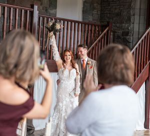 Wedding photography session inside rustic venue with wooden staircase.