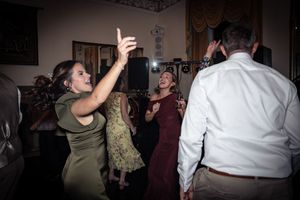 Dimly lit wedding reception dance floor with guests celebrating.