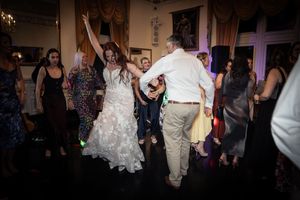 Dark reception venue with dance floor silhouettes and ambient lighting.