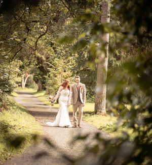 Tree-lined path with soft focus wedding photography creating a dreamy woodland atmosphere.