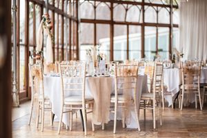 Elegant wedding reception venue with classic chiavari chairs and white table settings.