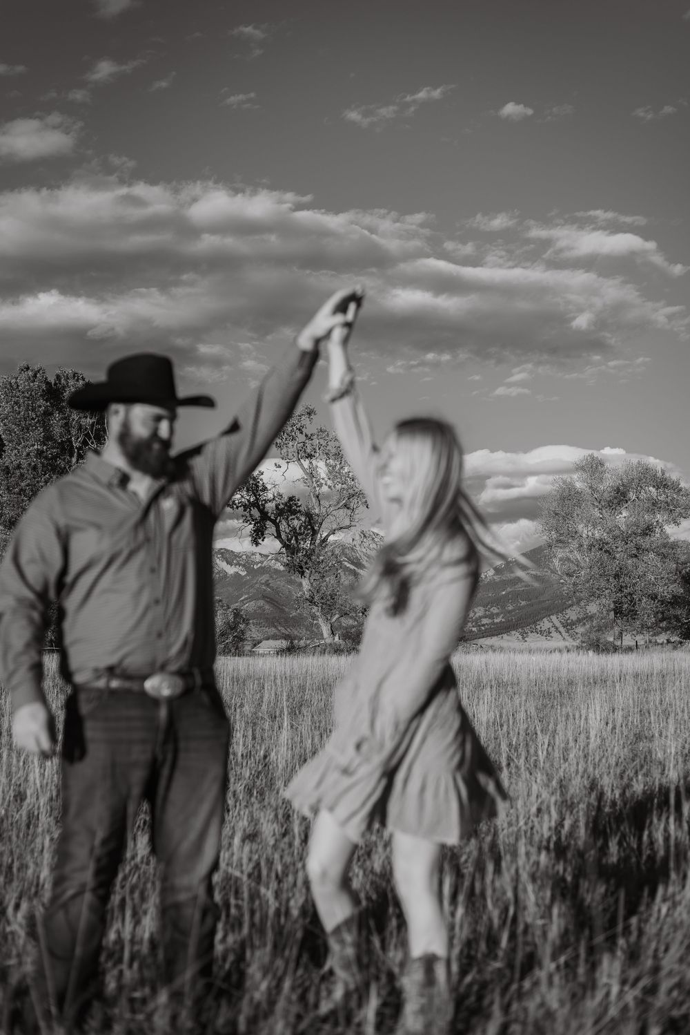 Artistic black and white sequence of couple dancing in rural field.