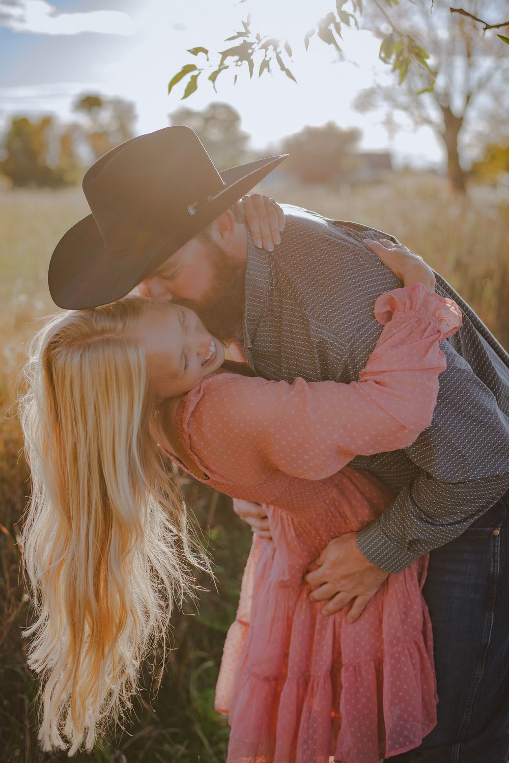 Romantic dip pose in wheat field during golden hour sunset.