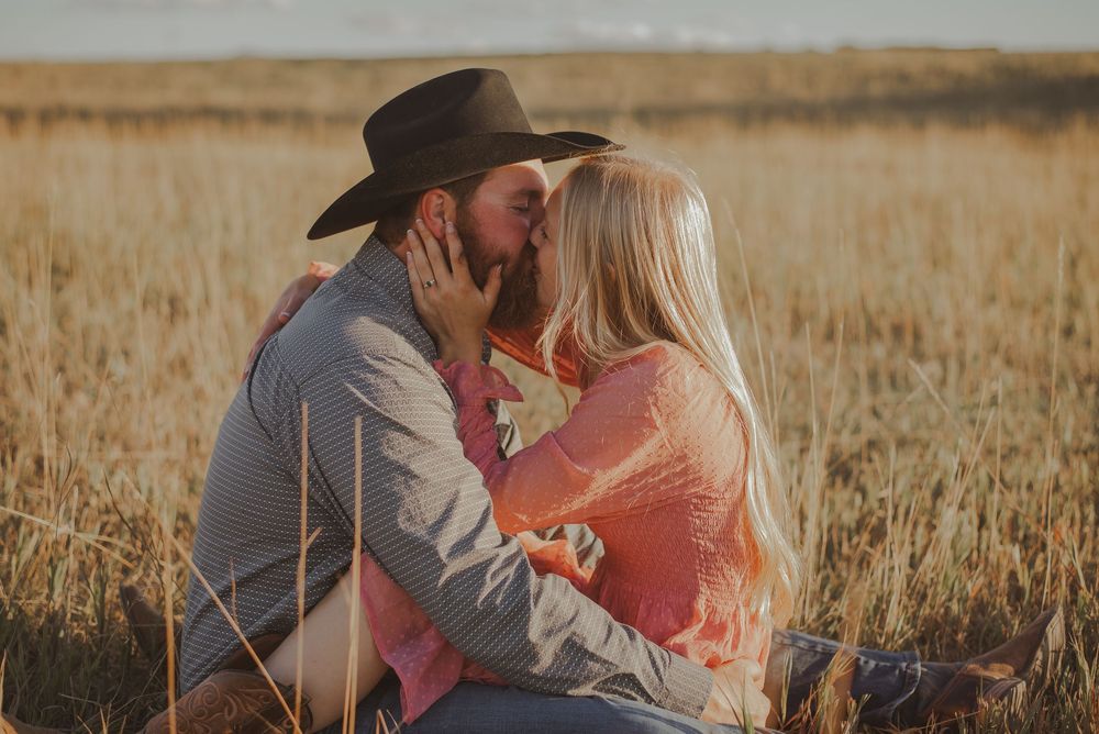 Romantic sunset photoshoot in rural field with warm lighting.