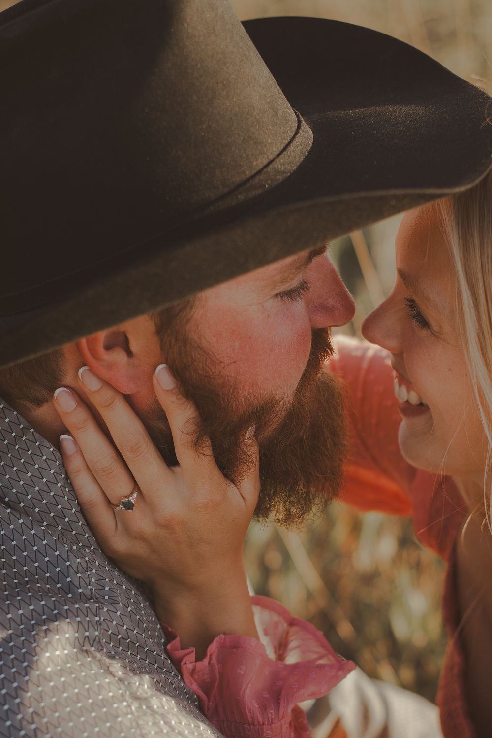 Intimate close-up moment between couple in western attire.