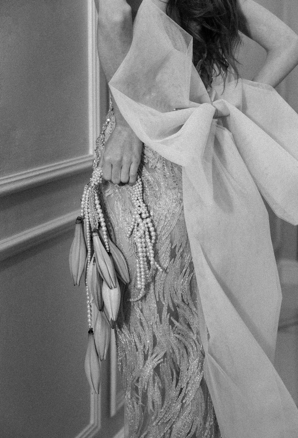 Elegant beaded gown with silver fringe details photographed in dramatic black and white.