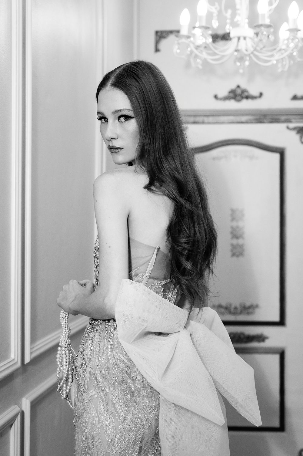 Fashion editorial in black and white showing glamorous evening gown with beaded details.