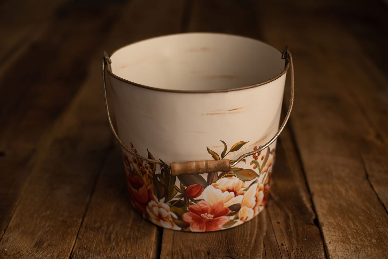 A sequence of Japanese ceramic bowls with floral designs arranged on a dark wooden surface in warm lighting.