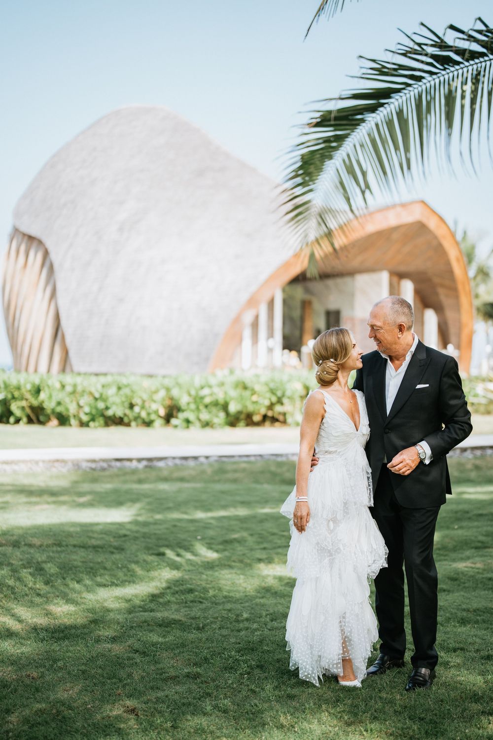 Sweet moments captured on a sunny lawn with dome structures in the background.
