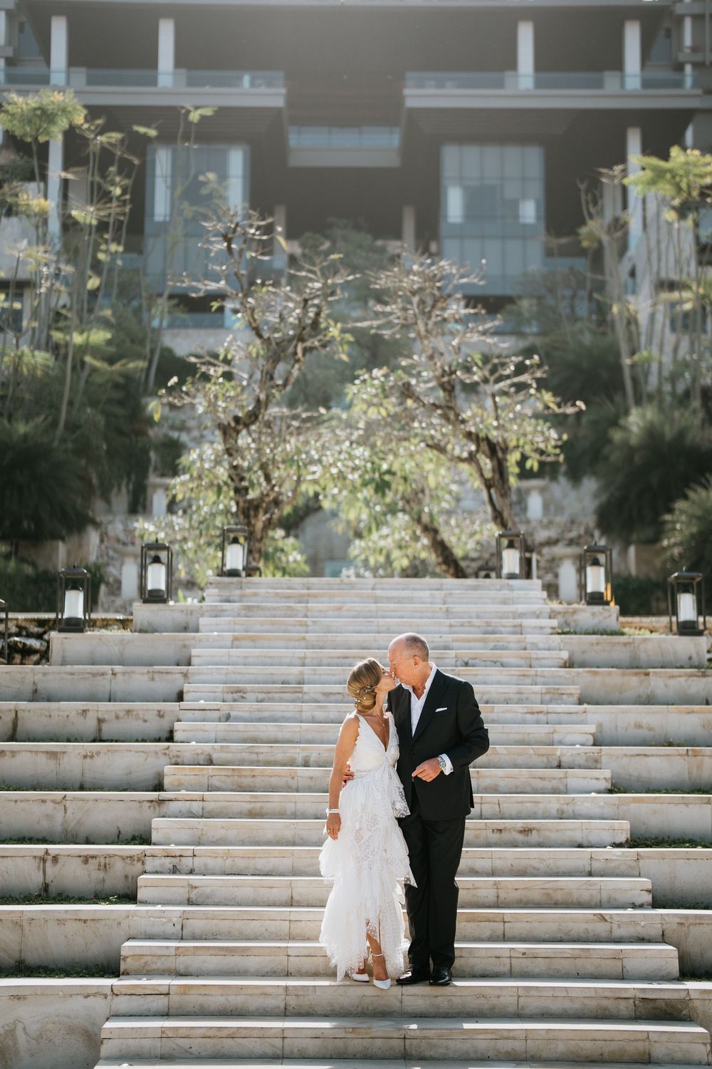 Elegant couple descending wide concrete steps at an outdoor venue.