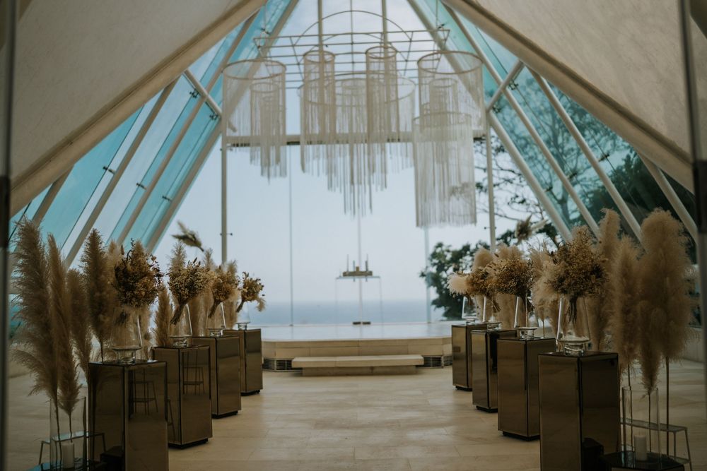 Modern chapel interior with glass ceiling and dried flower arrangements lining the aisle.