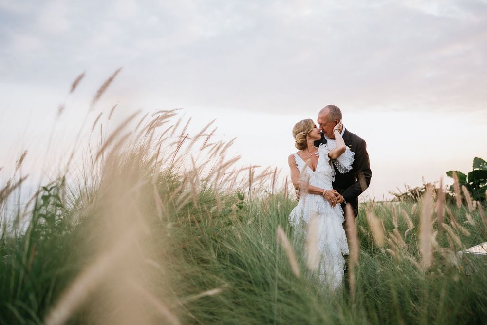 Artistic wedding photography sequence captured in seaside grass during sunset.