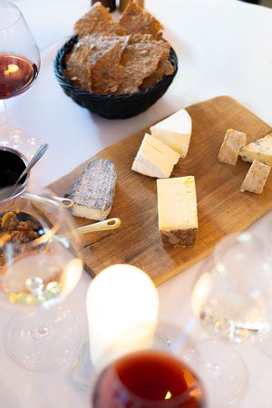 Artisanal cheese board with various aged cheeses and accompaniments displayed on a wooden serving platter.