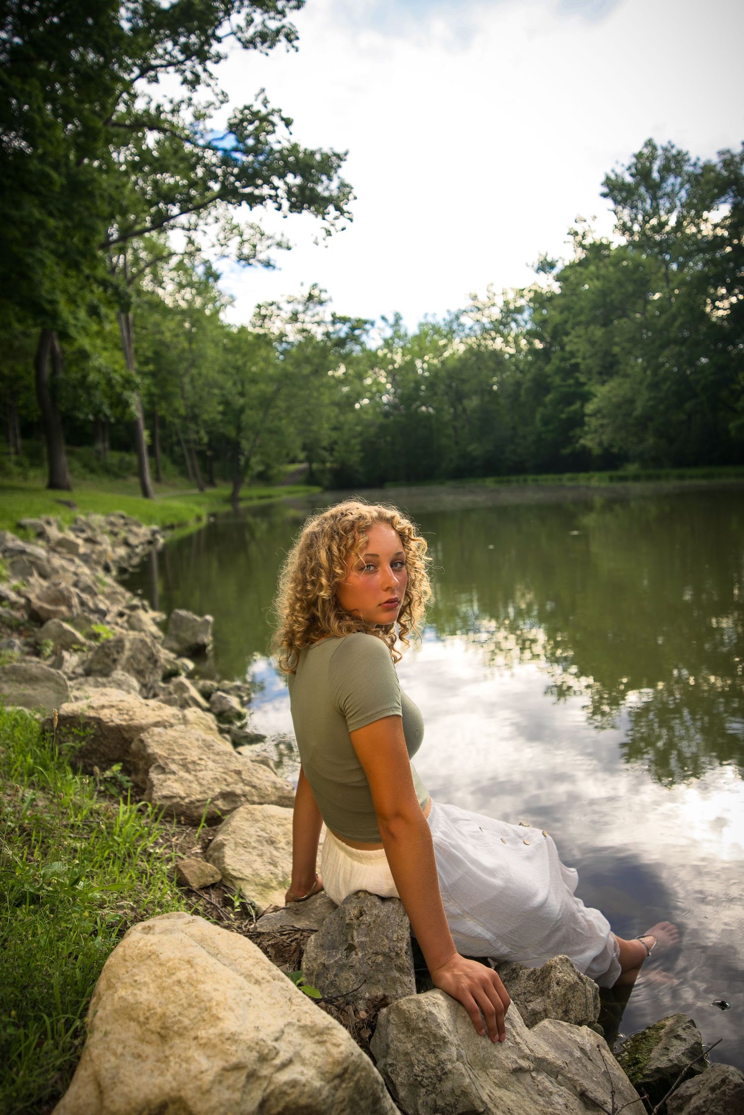 A serene lake scene with rocks and greenery along the shoreline.