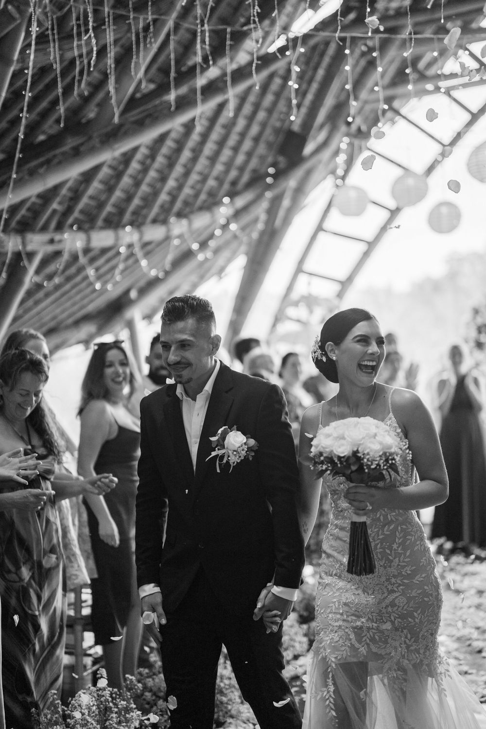 Wedding celebration in a venue decorated with string lights as guests celebrate.
