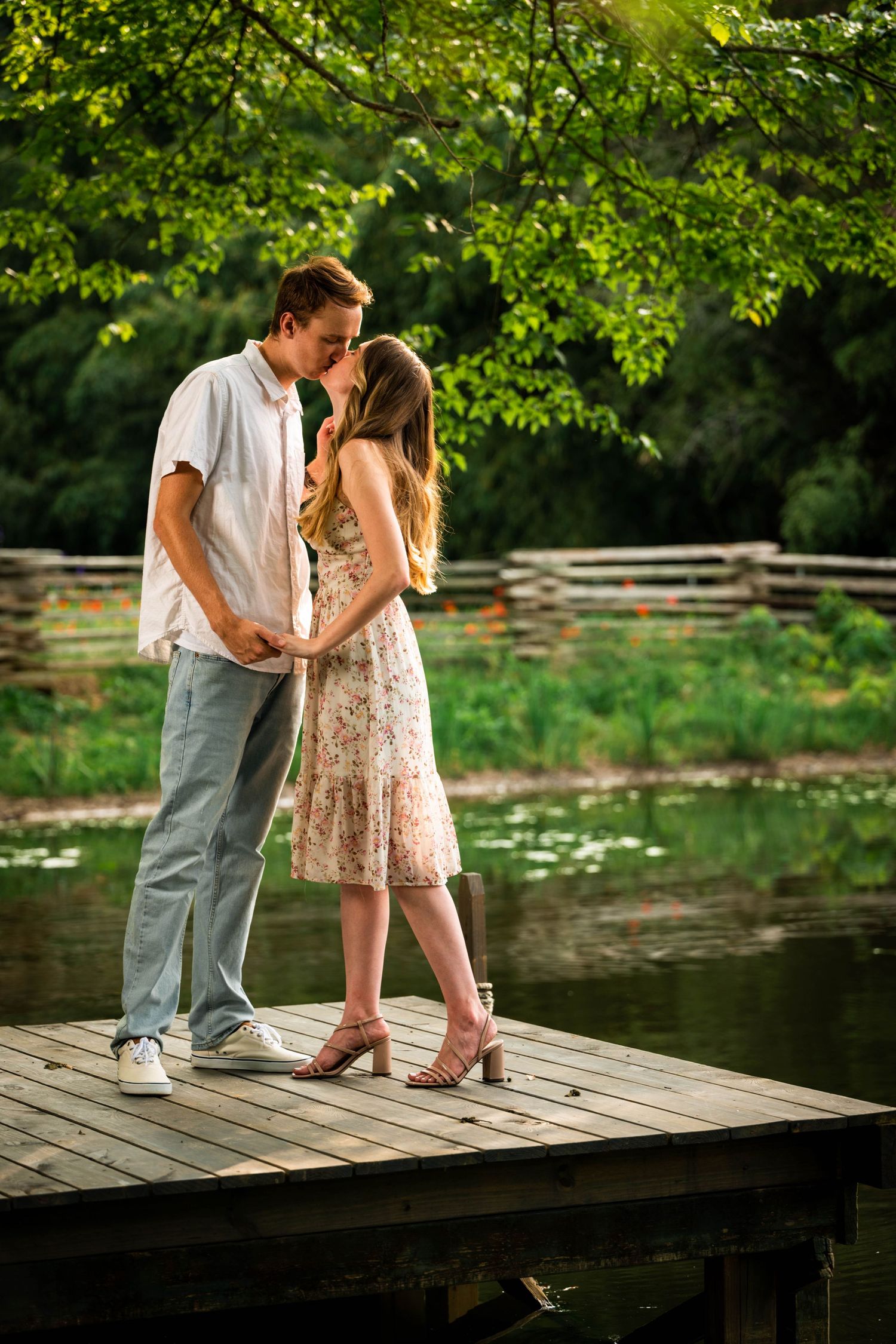 romantic poses on wooden dock with couple in summer attire.