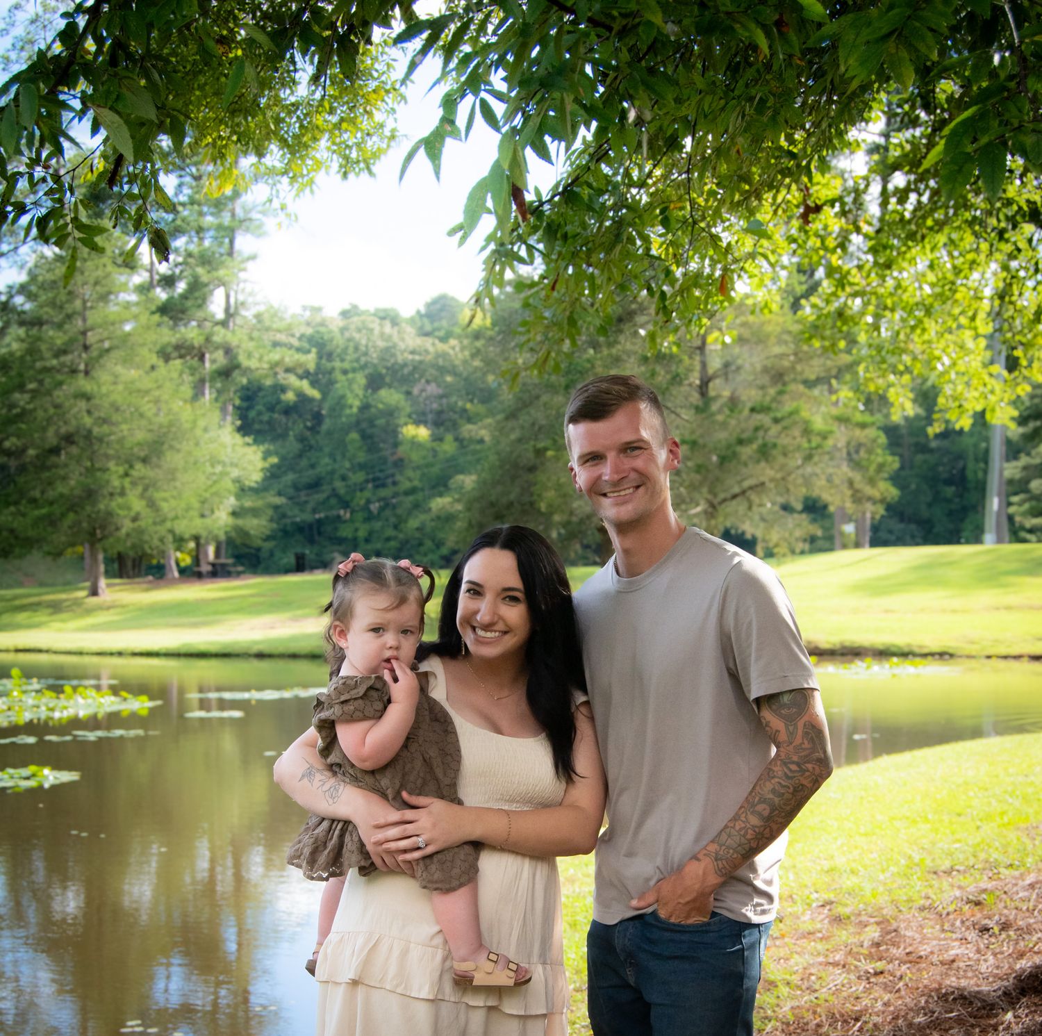 Casual outdoor family photos by a lake on a sunny summer day.