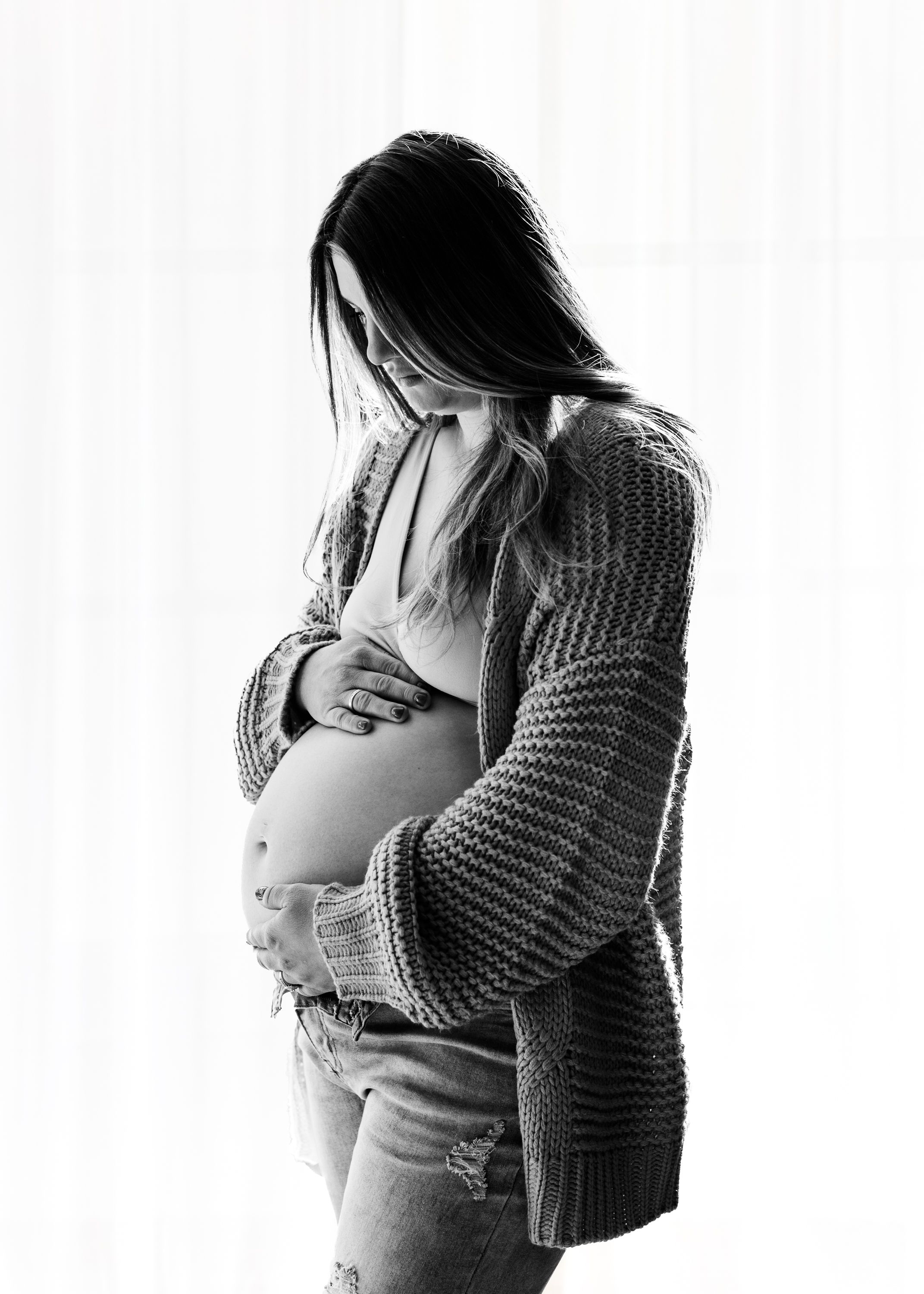 Black and white pregnancy progression photos showing intimate moments with partner in a knit sweater.