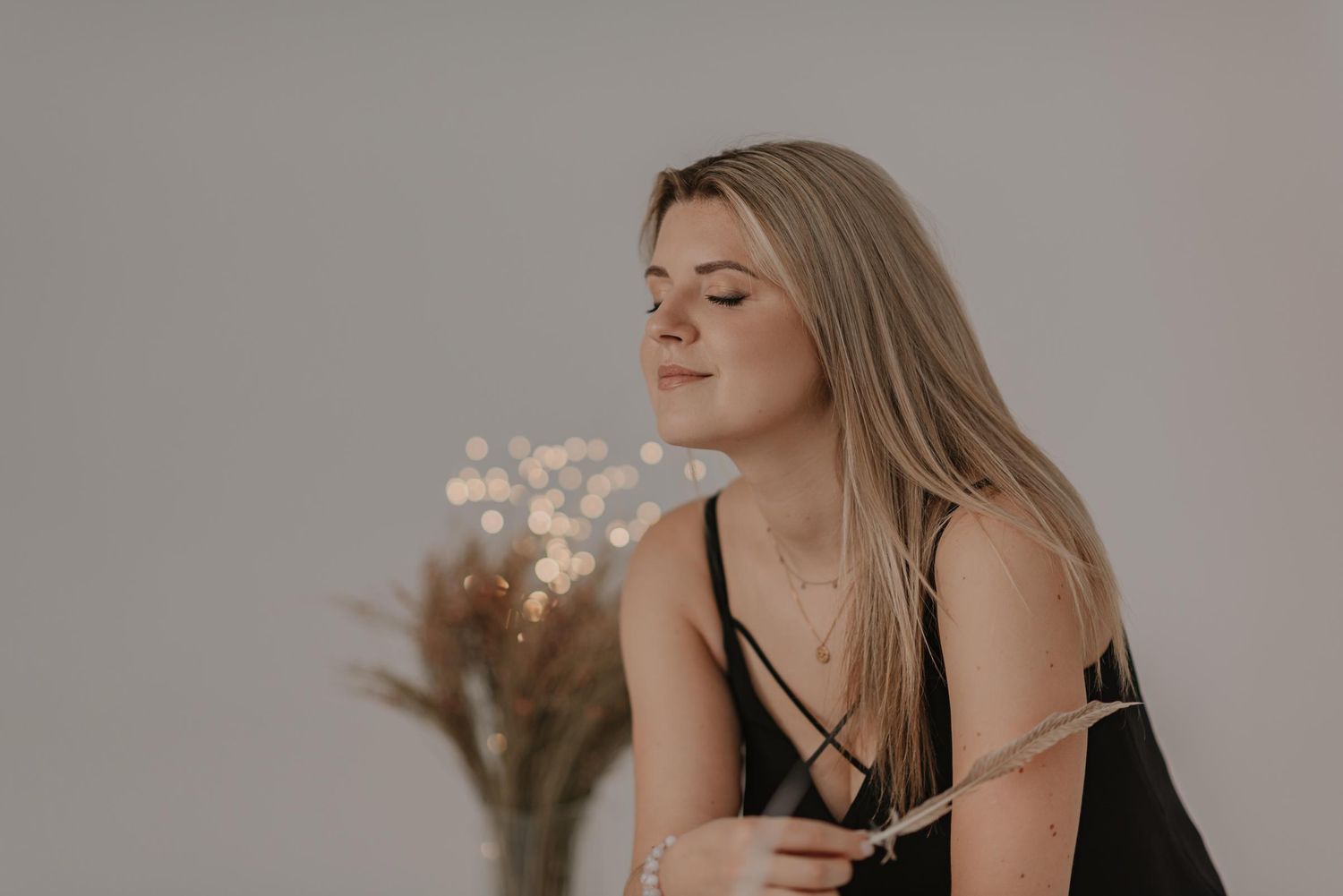 Minimalist indoor portrait with warm neutral tones and soft window lighting.