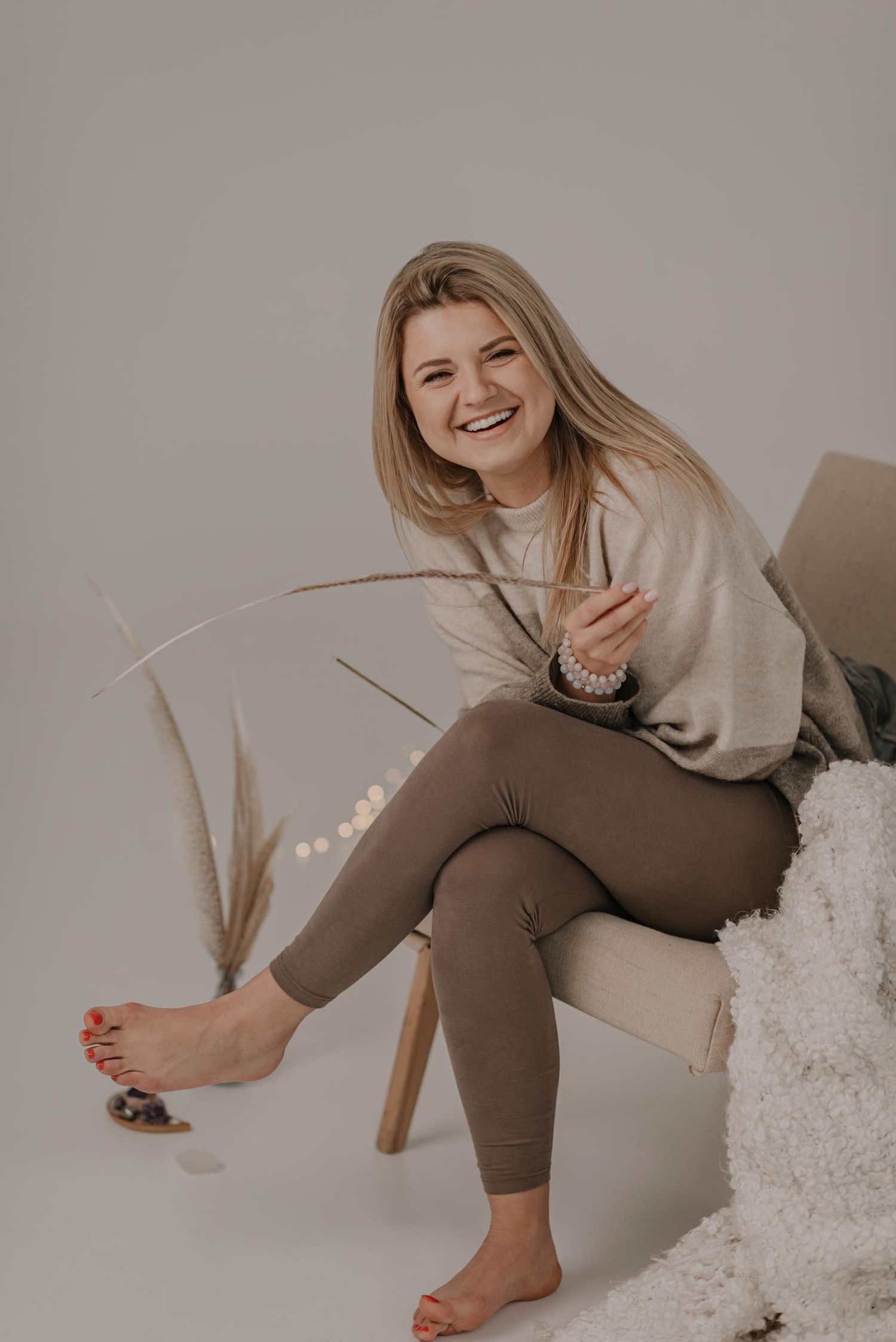 Casual lifestyle portrait with cream sweater and neutral decor elements.
