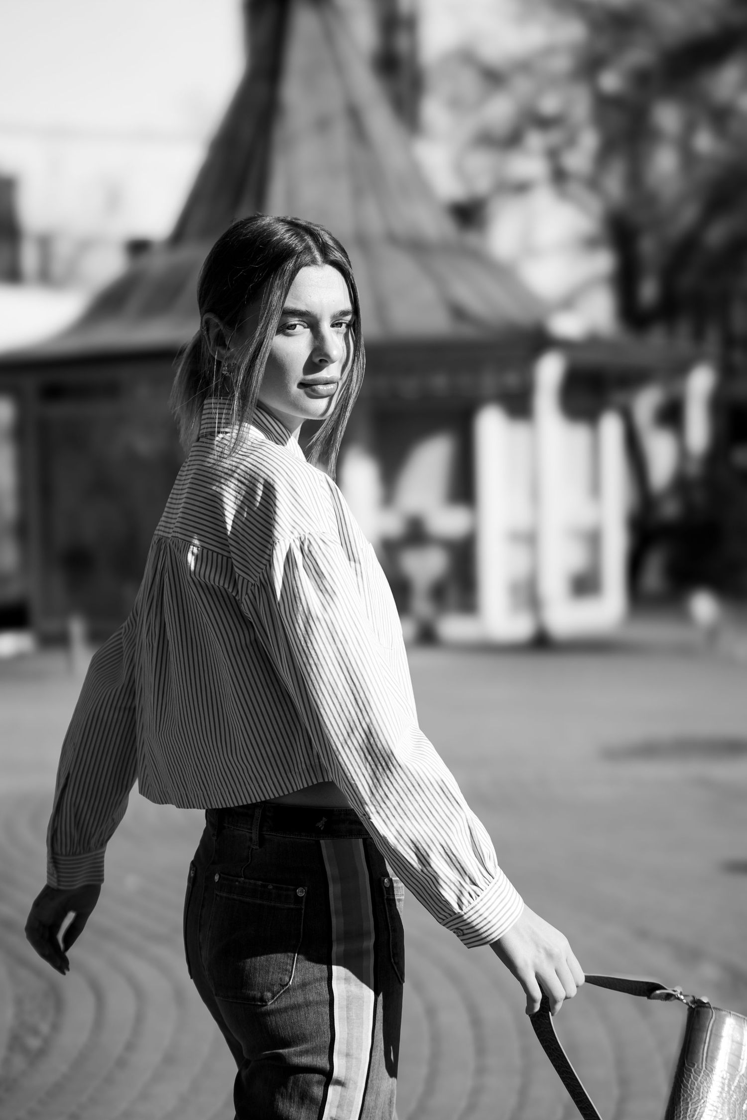 Black and white sequence of a person in casual wear walking along an urban street.