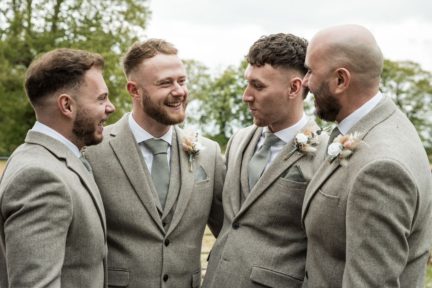 Groom laughing with groomsmen while getting ready at Kelham House