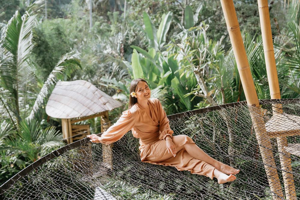 Relaxing scene of a hammock nestled among bamboo trees and tropical plants.