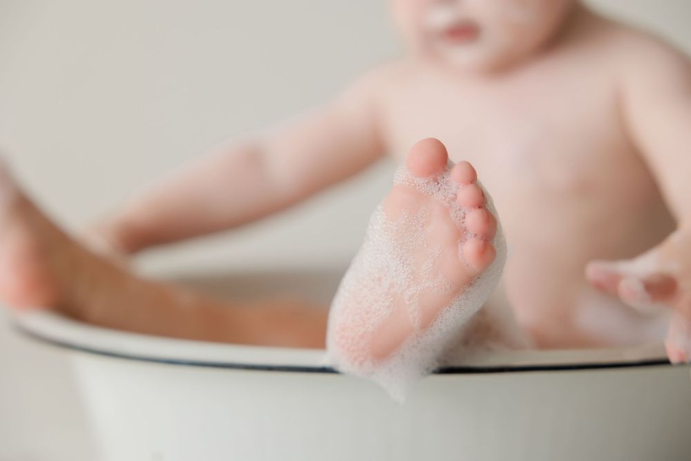 Close-up of tiny baby foot against white surface showing delicate details and soft skin.