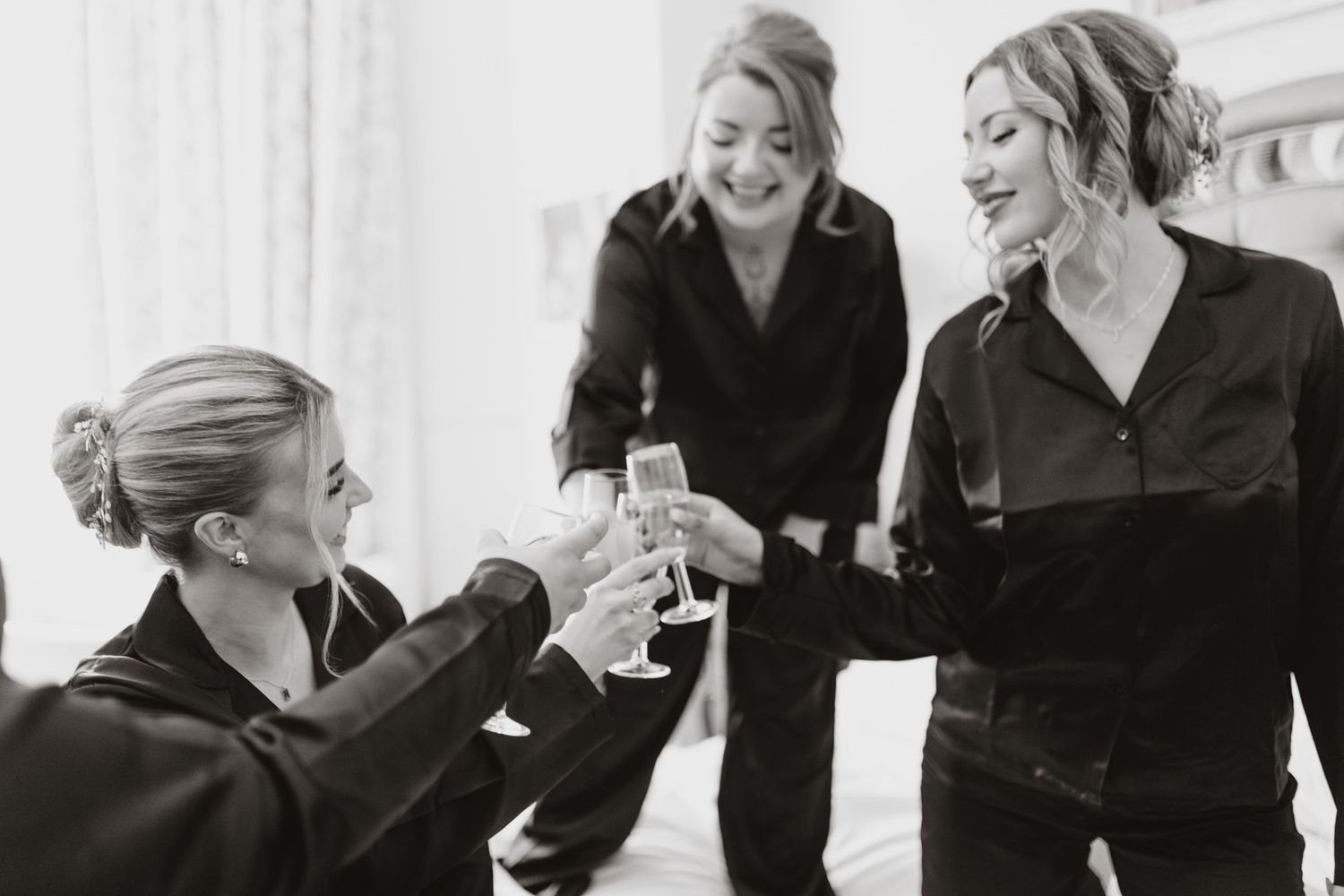 Bridesmaids having a toast in black pj's