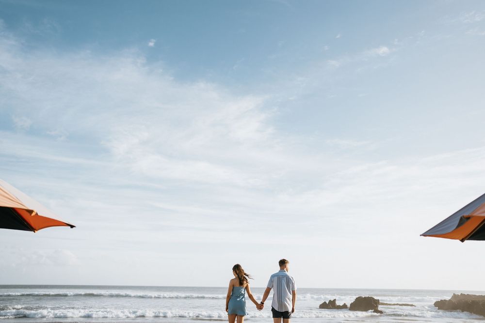 A couple splashing and playing together in the ocean waves at sunset.