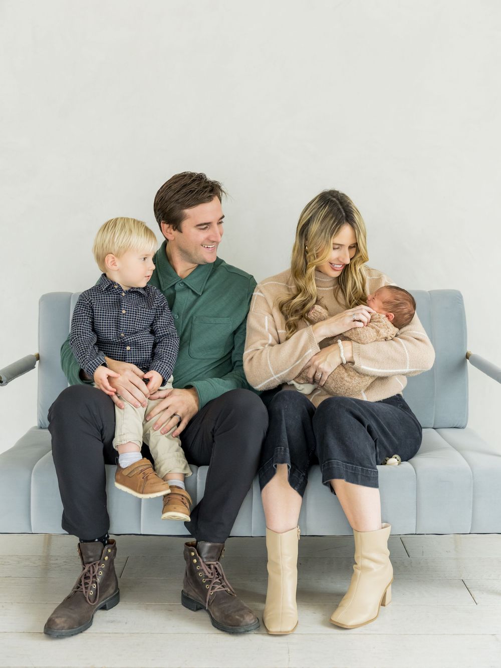 A family sits close together on a modern gray couch sharing intimate moments in four similar posed shots.